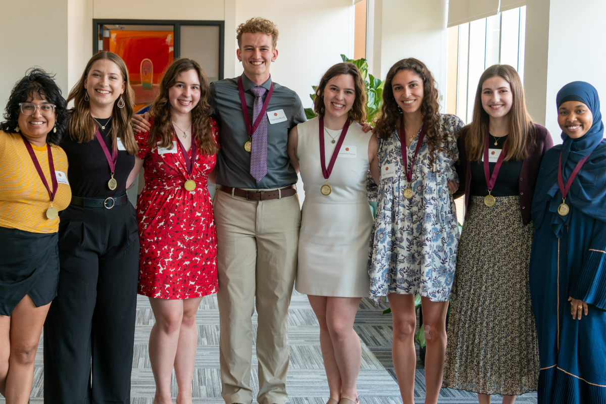 Scholars wearing medals at a reception gathering